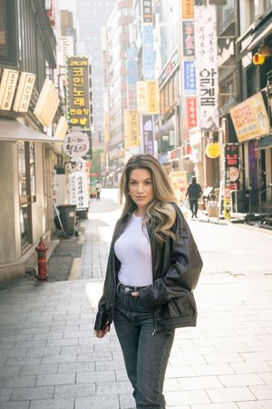Stylish street fashion photography in a busy Korean shopping district.