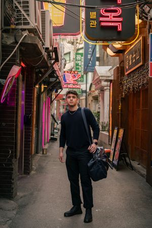 Narrow alley in Korea with colorful neon signs and traditional architecture.