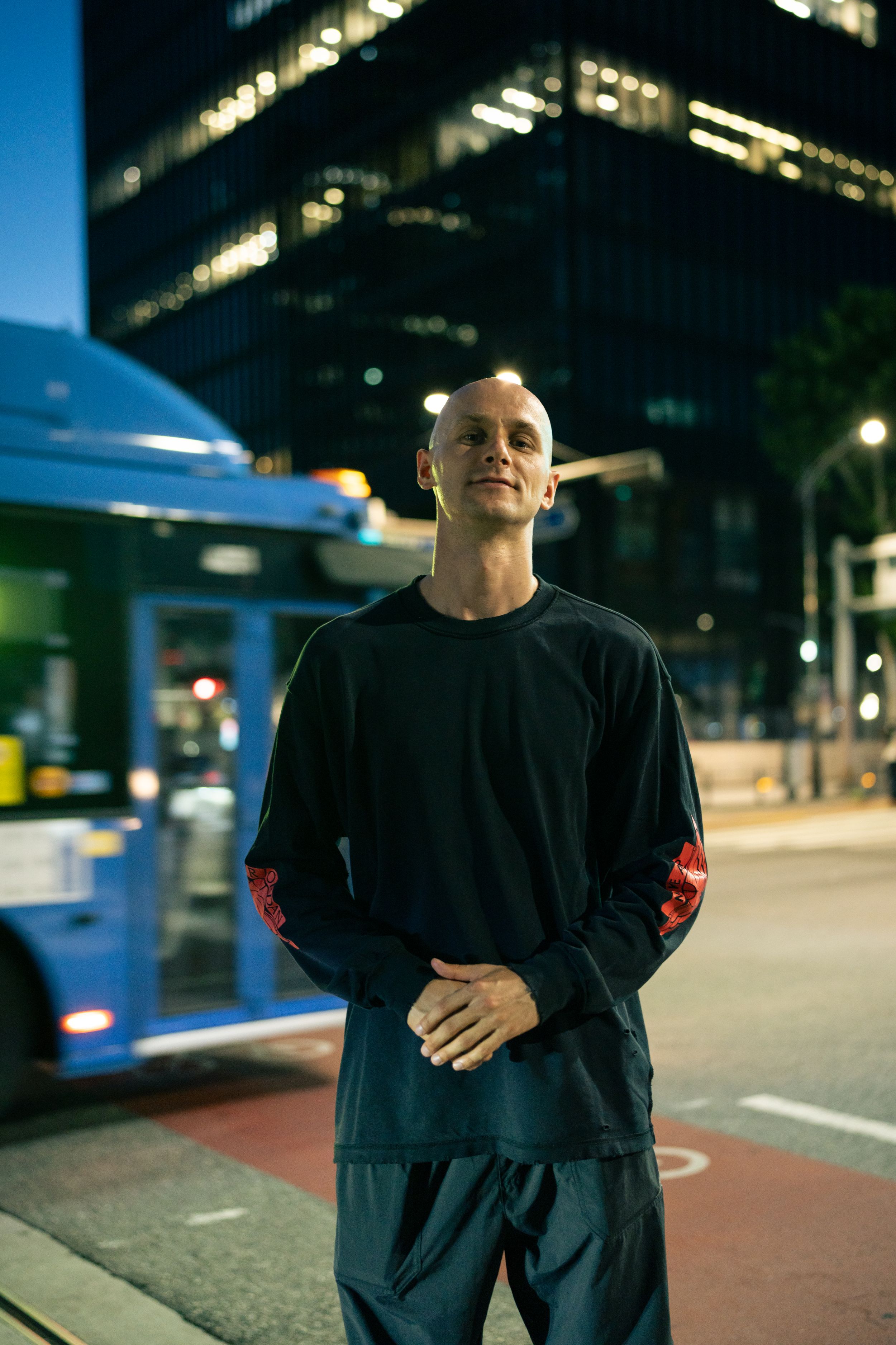Urban nighttime portrait with illuminated office building in background.