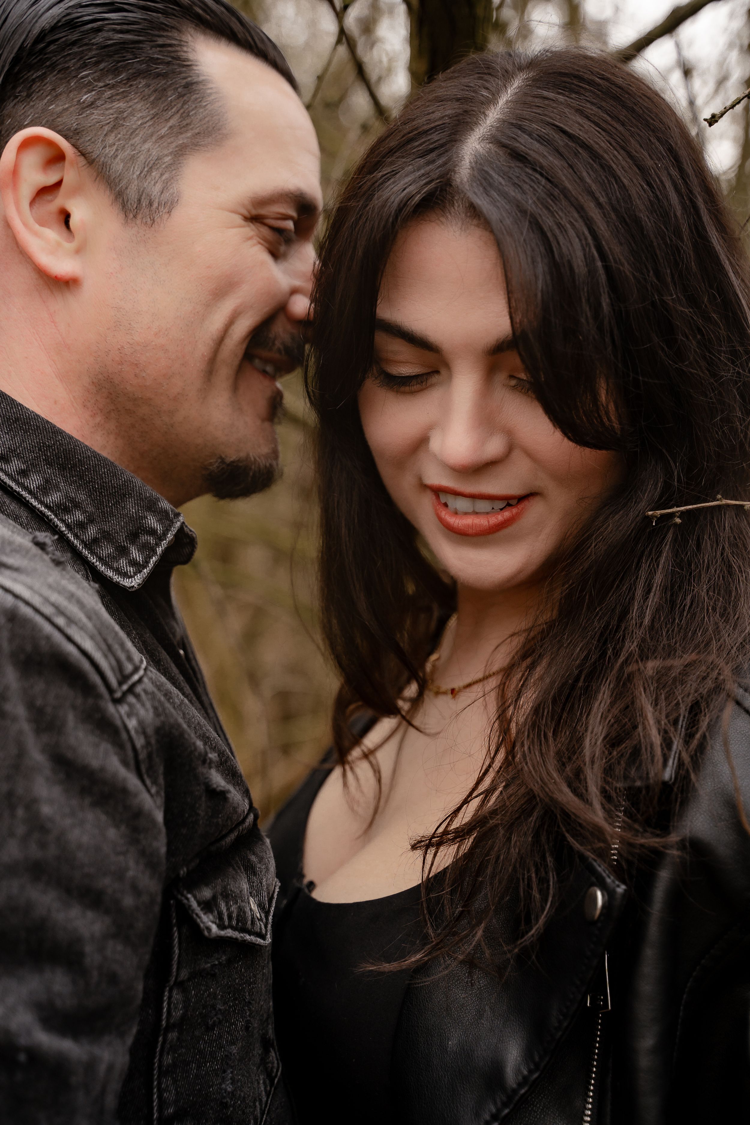 A romantic couple in black clothing share intimate moments outdoors in a series of candid photographs.