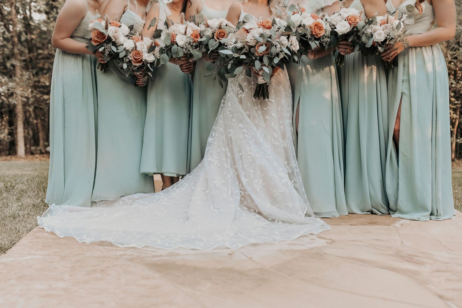 Bride surrounded by bridesmaids holding earthy toned bouquets at Whispering Oaks