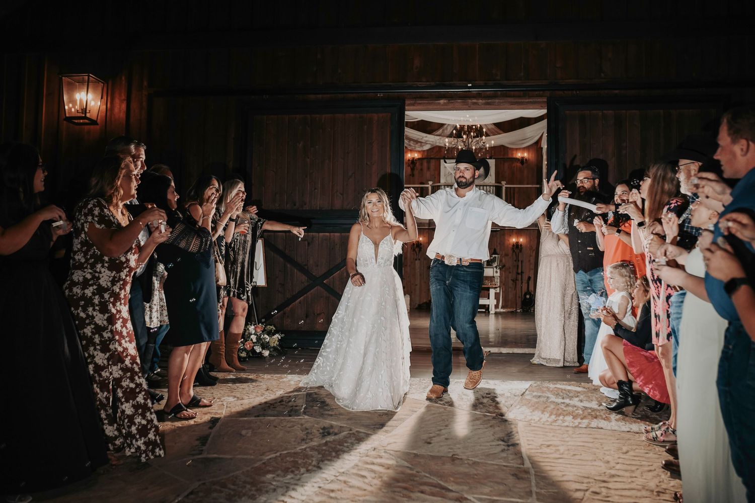 Guests blowing bubbles as the couple shares a joyful walk hand in hand