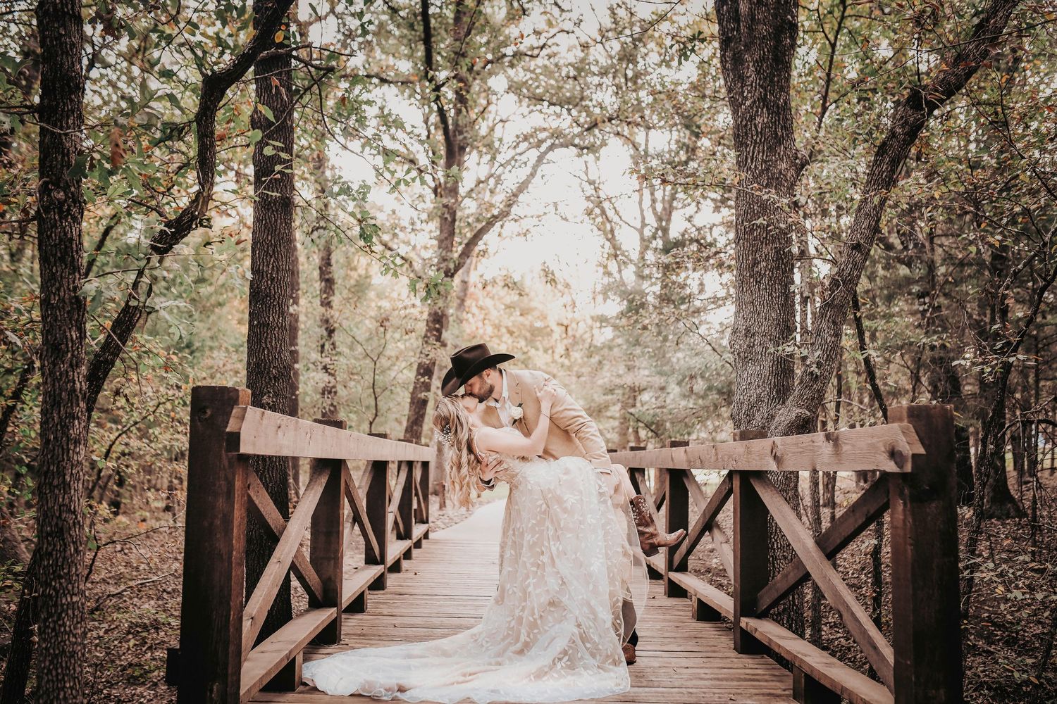 Bride and groom walking hand in hand under Whispering Oaks trees