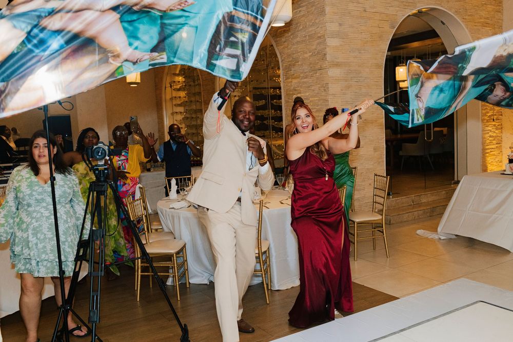 Wedding guests cheer and celebrate while watching a performance on the dance floor.