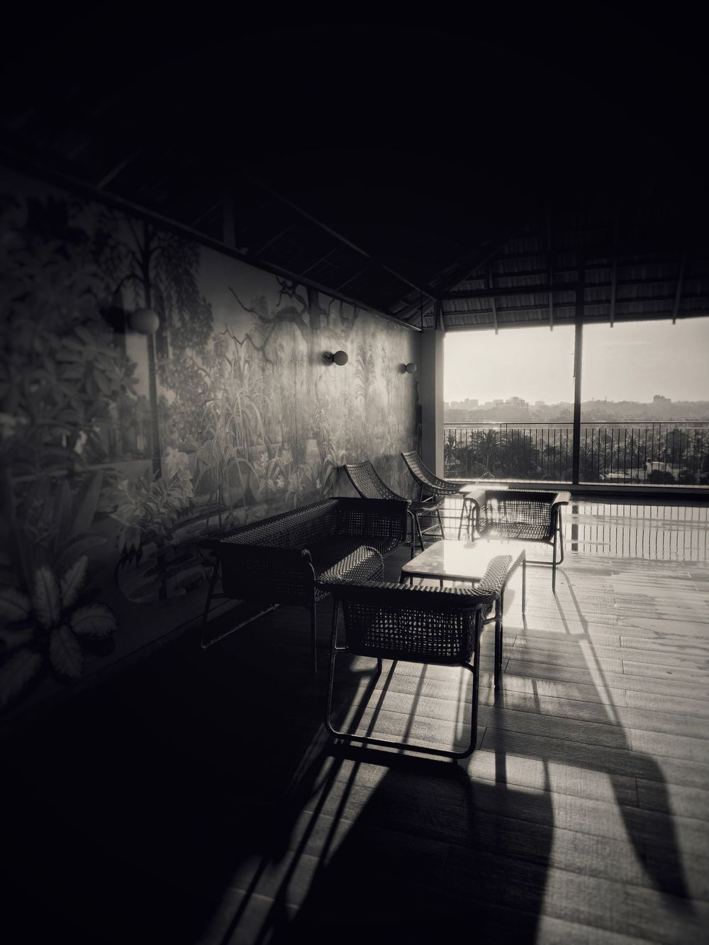 Dark urban space with dramatic shadows and light streaming through windows.
