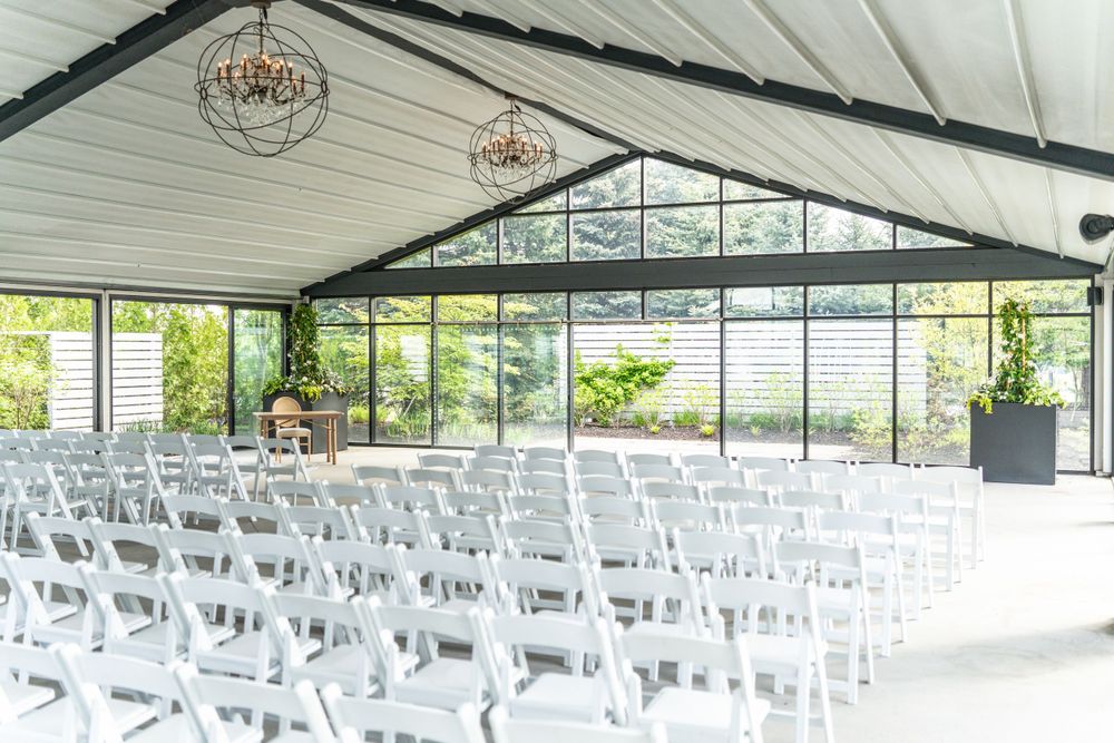 Whistlebear Golf Club - White ceremony chairs arranged in rows under a covered outdoor pavilion.