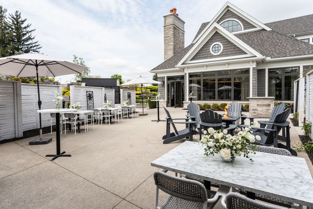 Whistlebear Golf Club - Elegant outdoor patio seating area with umbrellas and ocean views at an upscale waterfront venue.