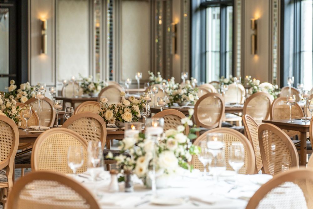 Luxurious dining room with wicker chairs and elegant table settings in warm ambient lighting.