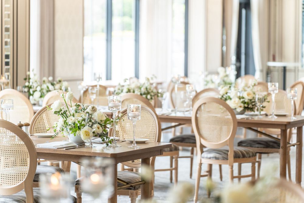 Upscale dining room with wicker chairs and elegant table settings.