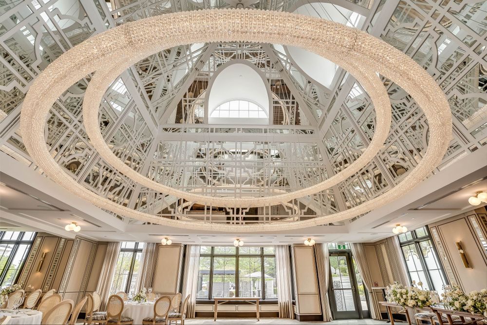 Grand reception hall with intricate ceiling architecture, panoramic windows, and classic white decor.