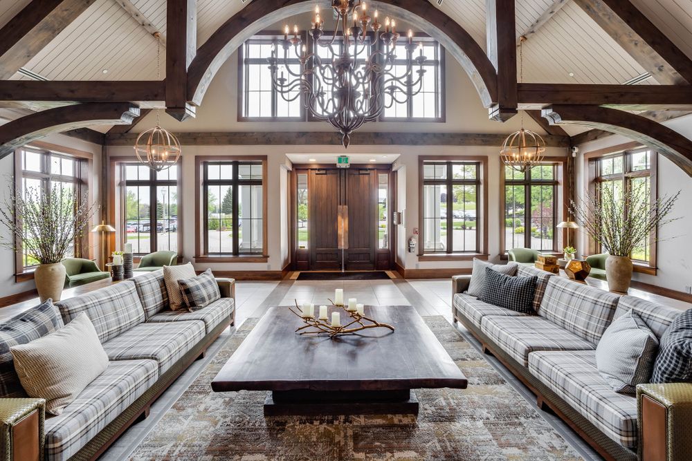 Luxurious gathering space with vaulted ceiling, exposed beams, and comfortable built-in seating along windows.
