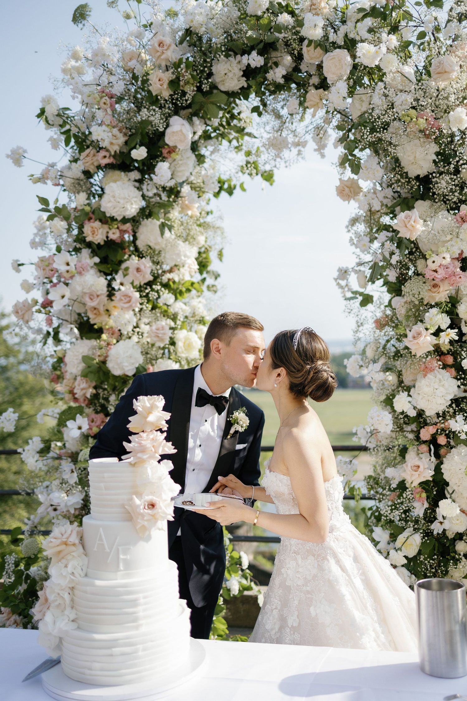 Romantic wedding scene with white floral arch and elegant tiered cake showing key moments during a couple's special day.