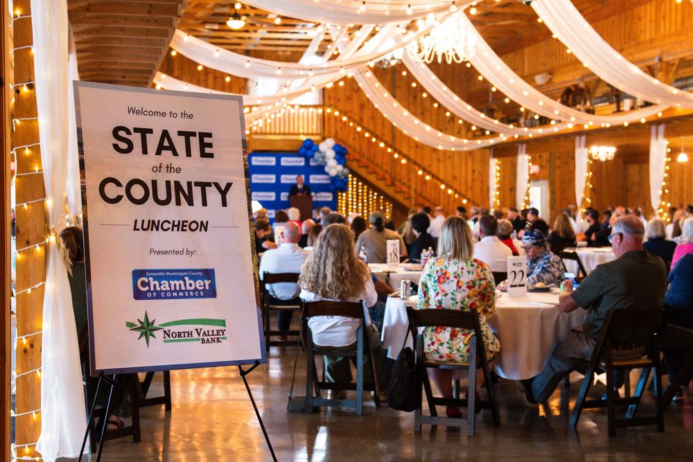 State of the County Luncheon event hosted by Chamber of Commerce with guests seated at round tables in a decorated venue.