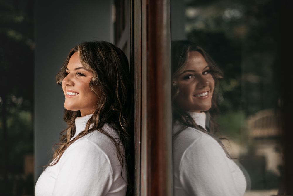 Artistic style Senior portrait in front of a reflection at seaside shops courtyard created by photographer Matt Johnson with MJphotograph