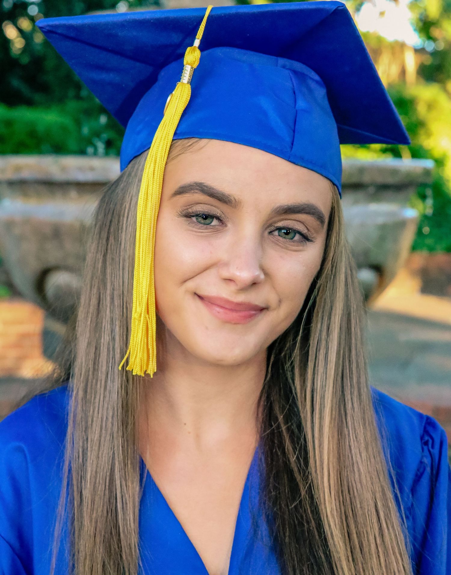 Senior posing in cap and gown in nature setting,  Windsor Ontario taken by Tasha Cannaday.