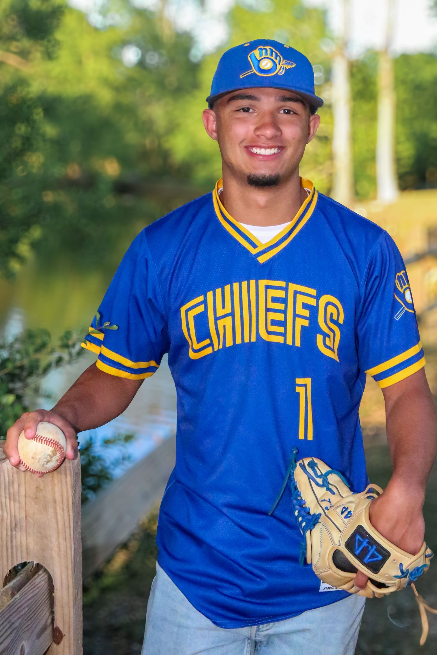 Baseball-themed graduation photo with senior in a park, taken by local Windsor Ontario Photographer.