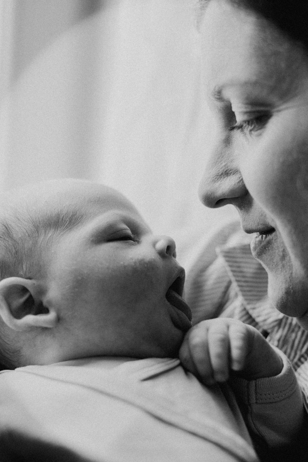 A tender black and white moment between parent and infant as they share an intimate interaction.