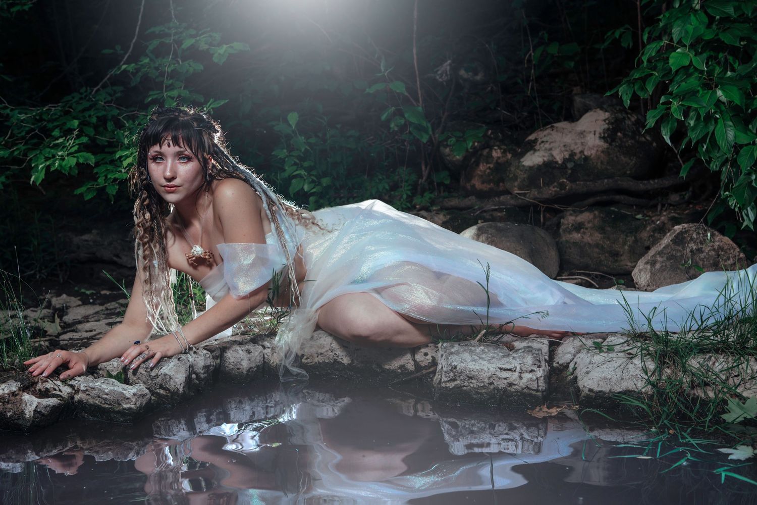 Ethereal bridal photography session in a misty forest setting with dramatic lighting.