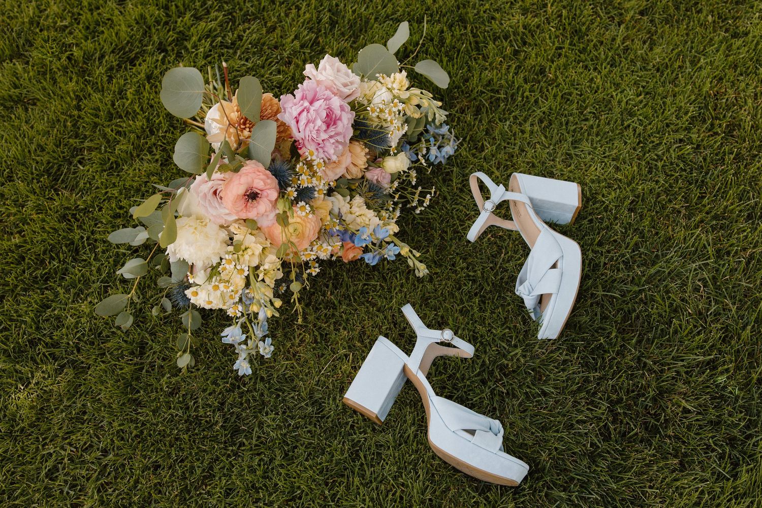 Elegant white wedding shoes with delicate lace details captured in dramatic black and white lighting.