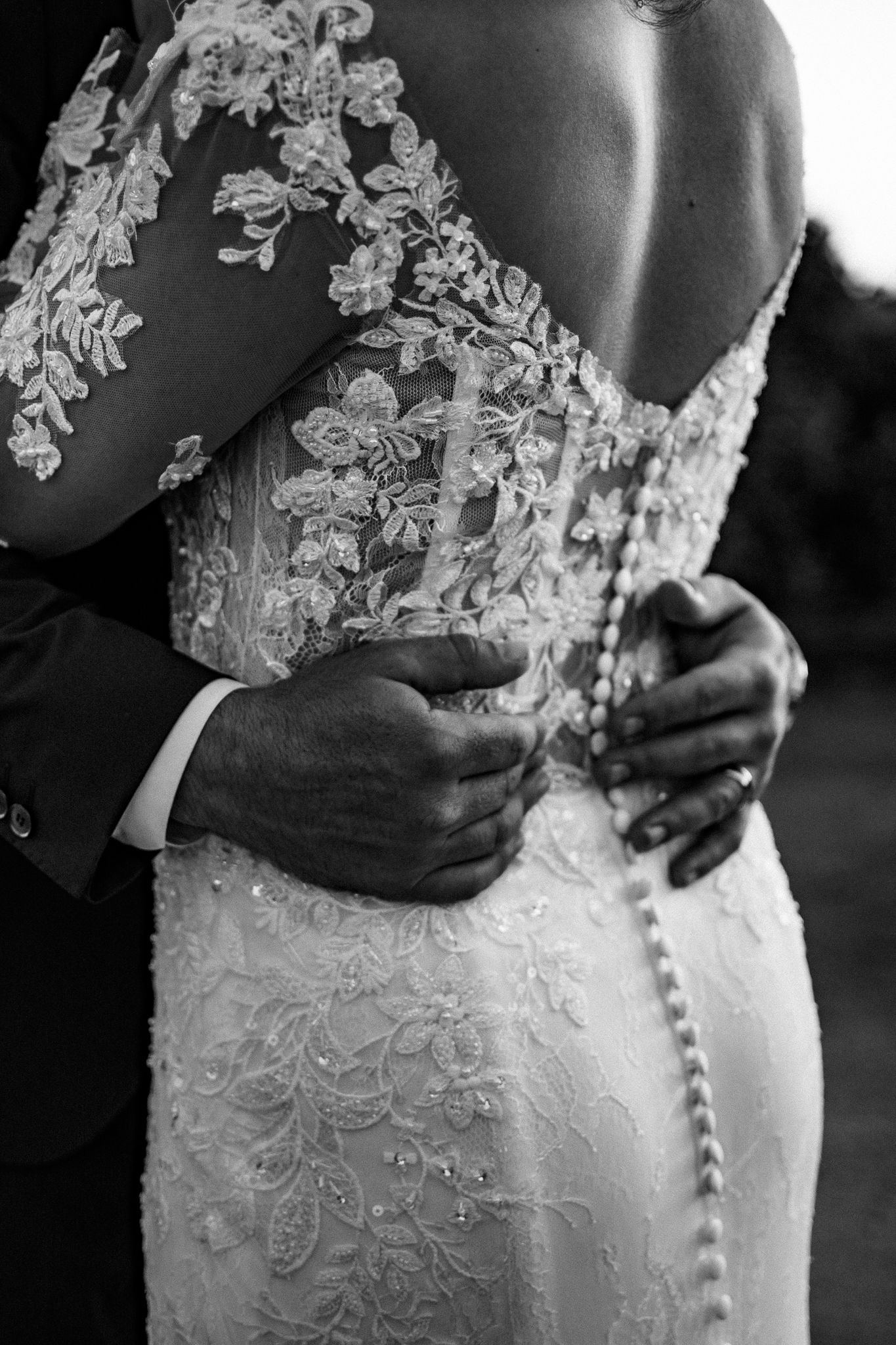 Picture of a couple with the male's hands, around the female's waist, resting on her lower back.
