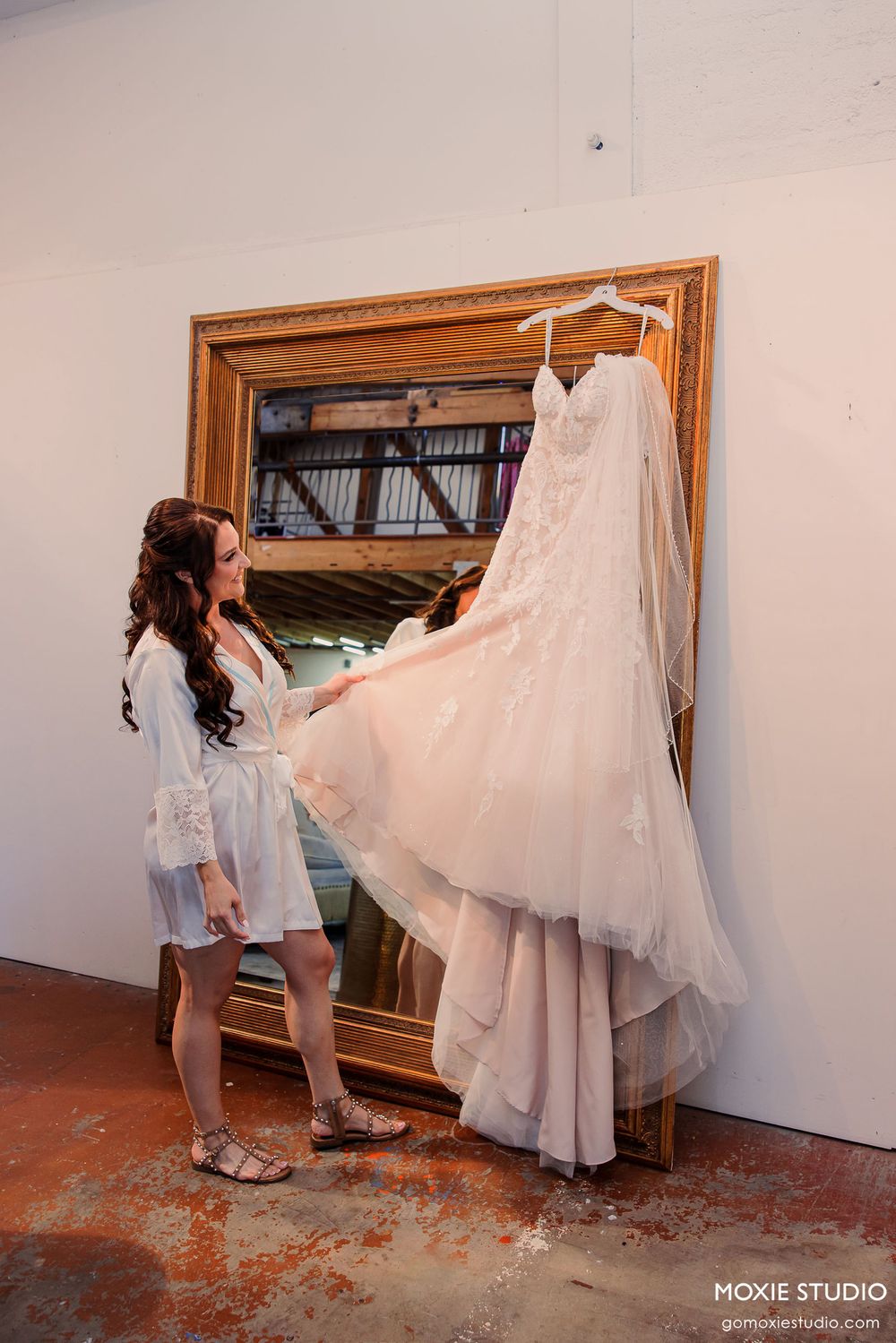 Wedding dress preparation sequence showing a white gown being hung and arranged.