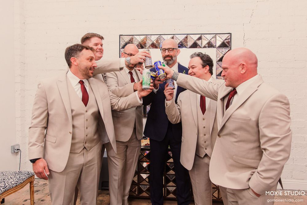 Group of groomsmen in beige suits gathered together at wedding celebration.