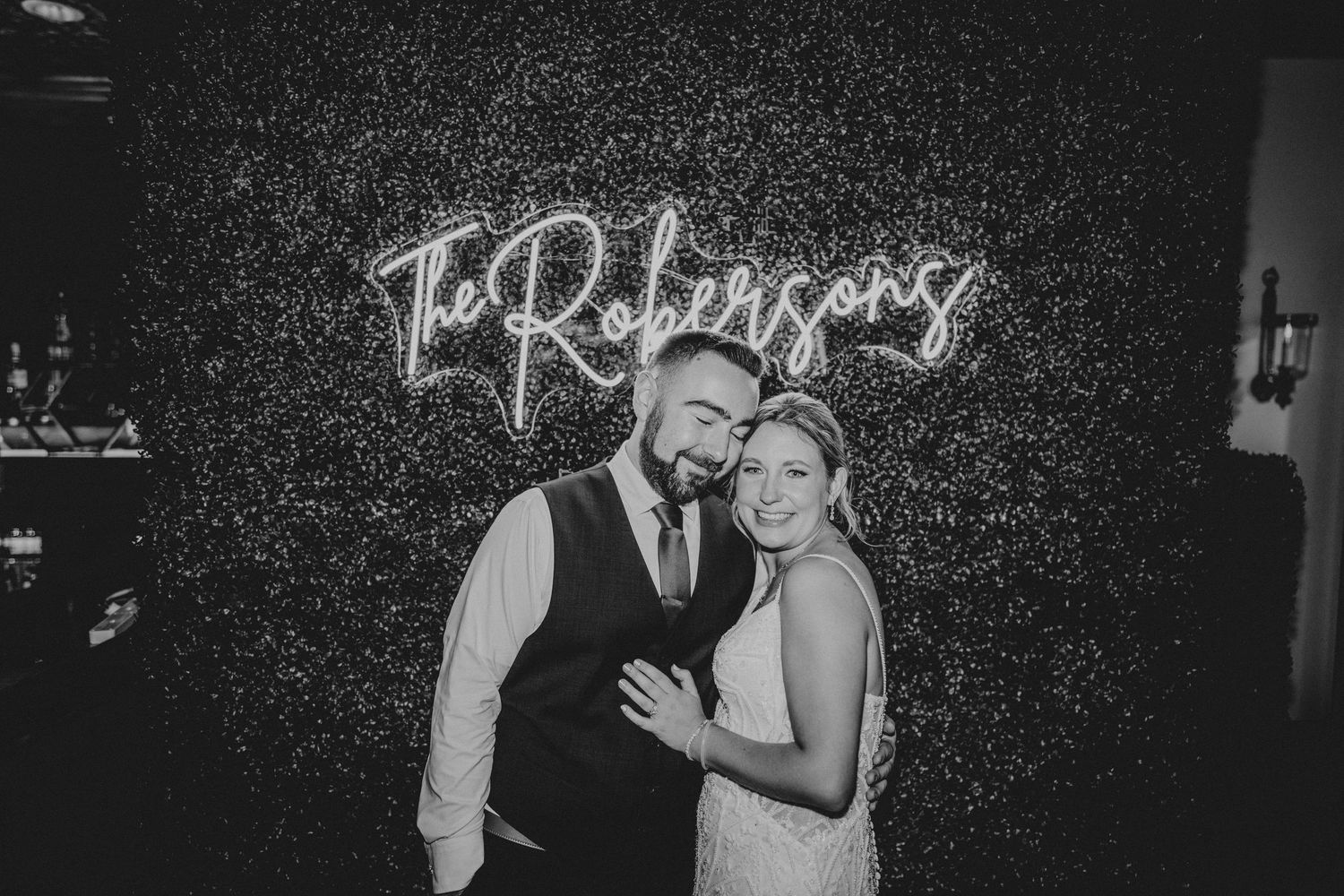 Black and white wedding photos arranged in a filmstrip style showing romantic moments between a couple at their reception.