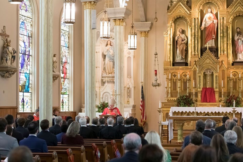 Interior of ornate St. Peter's Cathedral in Montgomery, Alabama with stained glass windows and golden altar.