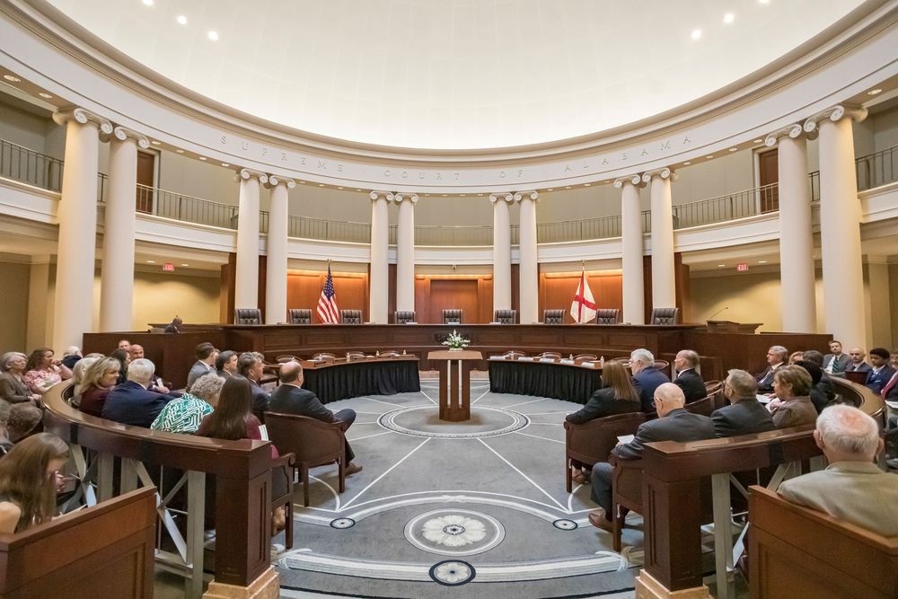 Panoramic view of a grand circular legislative chamber with white columns and tiered seating.