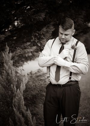 A series of black and white photographs showing groomsman portrait  in formal attire adjusting their tie in a wooded setting.
