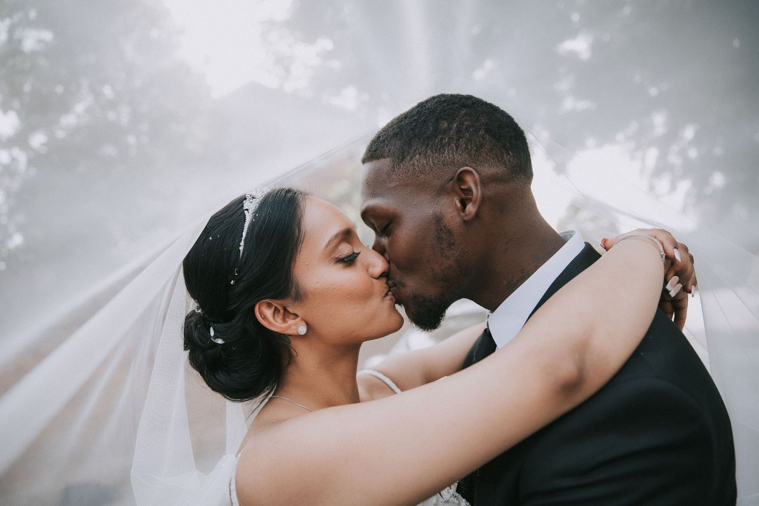 Romantic wedding portrait series with soft lighting and ethereal veil movement.