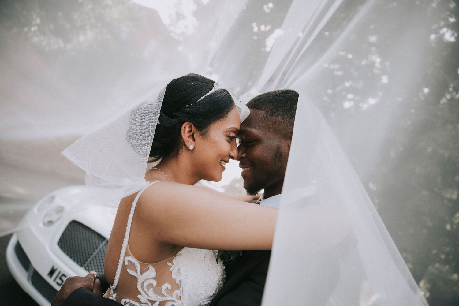 Close-up wedding photos showing tender moments between newlyweds with flowing white veil details.