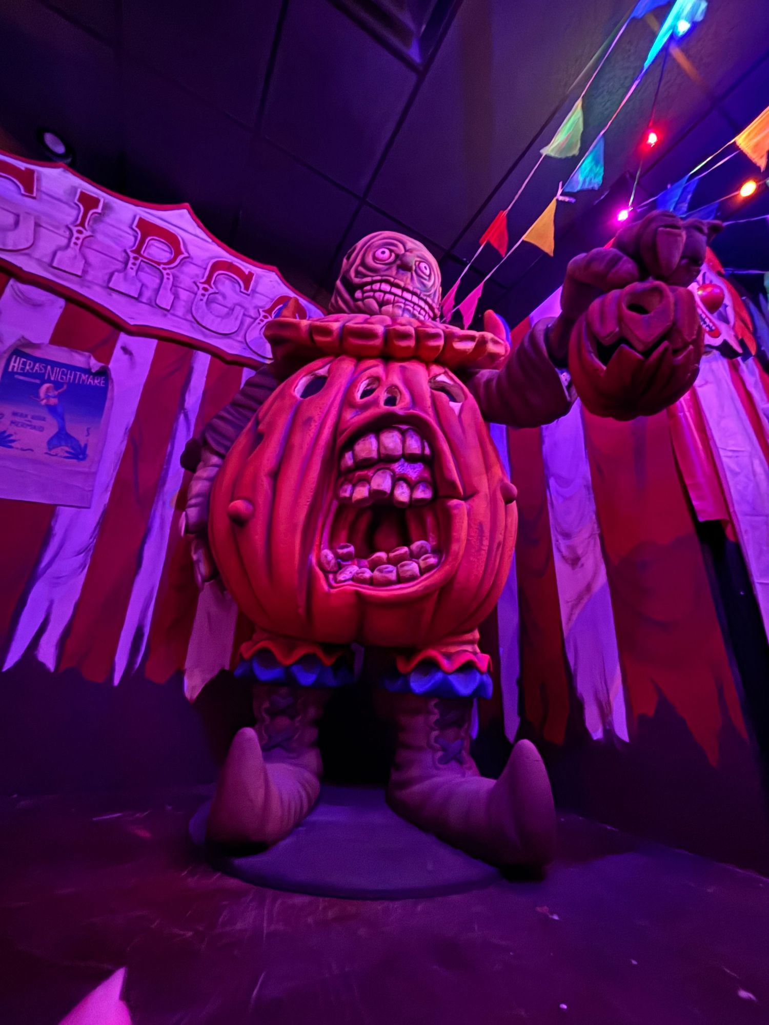 A series of carved jack-o'-lantern pumpkins illuminated with purple and blue lighting creating a spooky Halloween display.