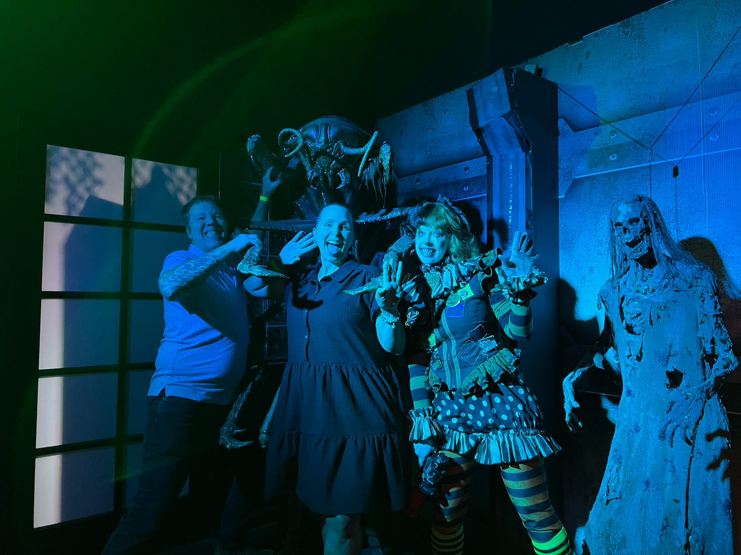 A group of people dancing at a party under blue lighting in a dark room.