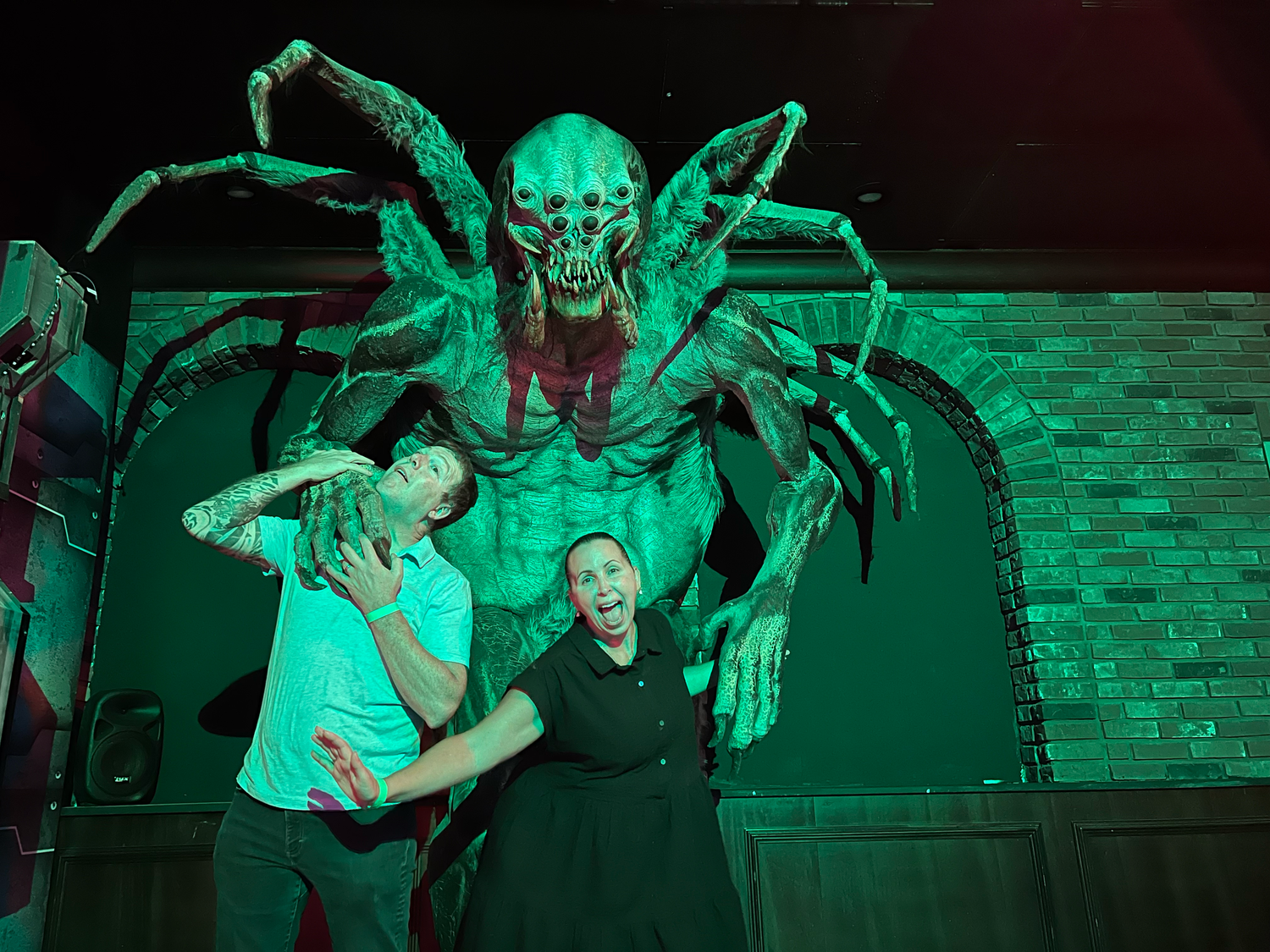 A dramatic performance with spooky green lighting features a menacing winged creature.