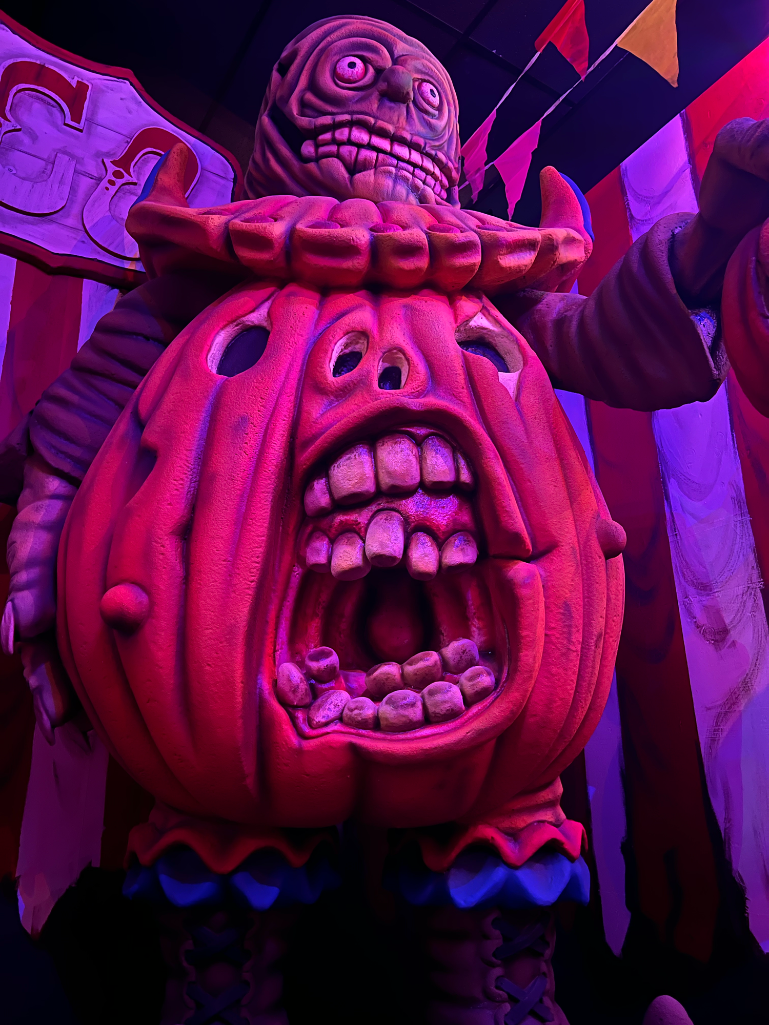 A series of glowing red Halloween pumpkins with carved scary faces illuminated in dramatic purple lighting.