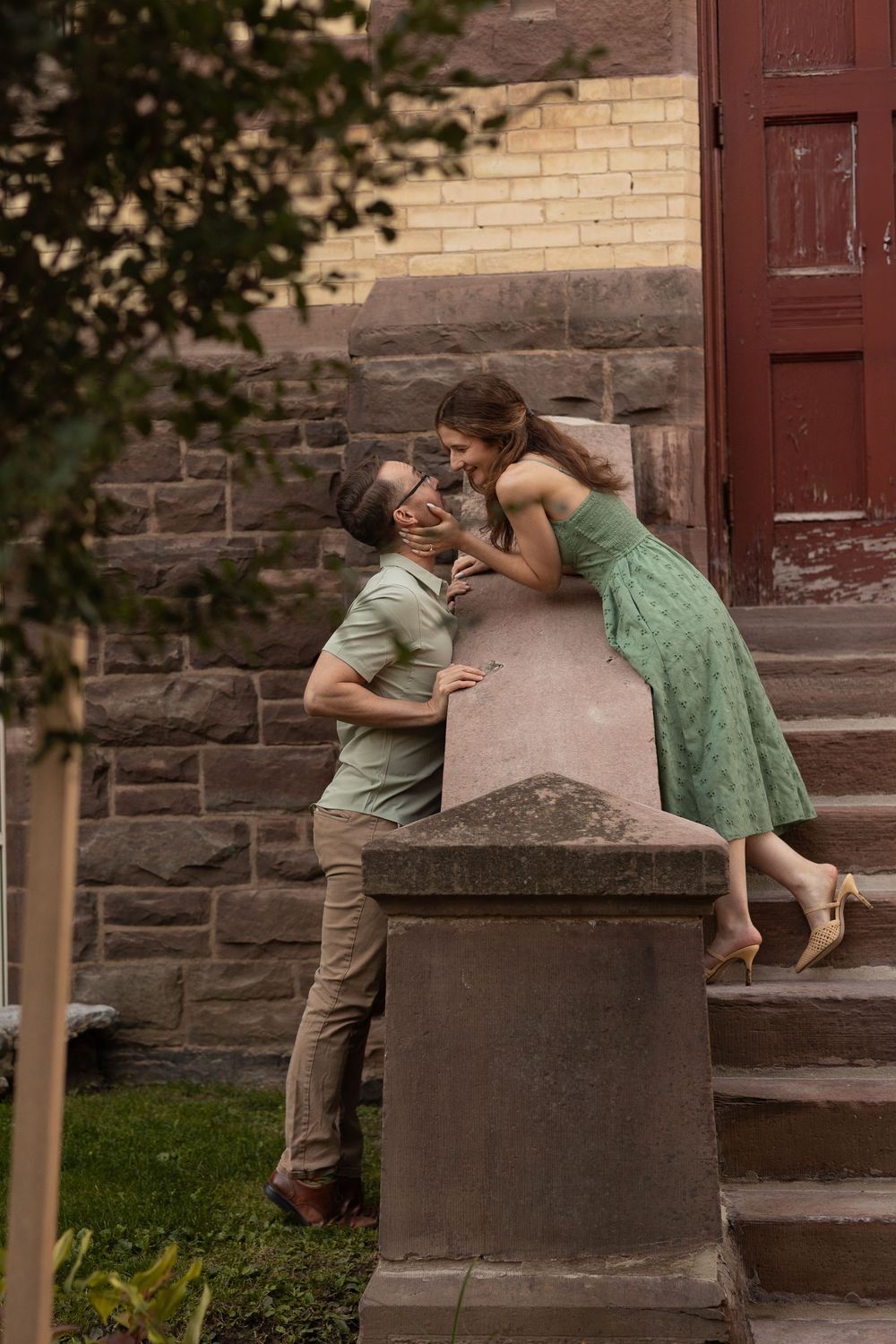 A couple shares a romantic moment on stone steps in front of a brick building, shown in three sequential photos.