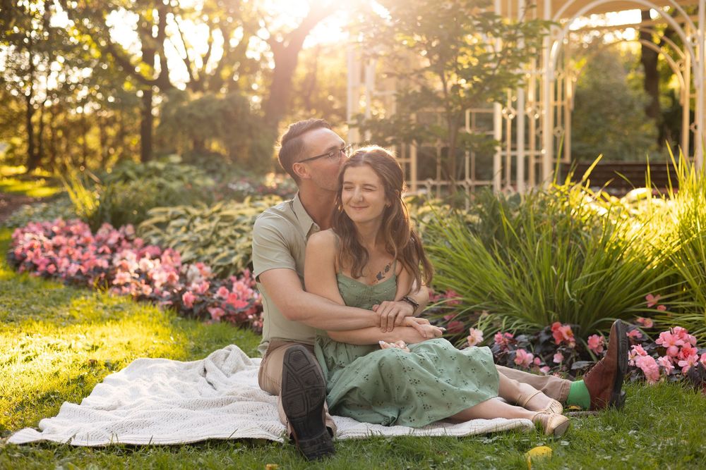 A romantic sunset photoshoot in a garden with pink flowers and golden hour lighting.