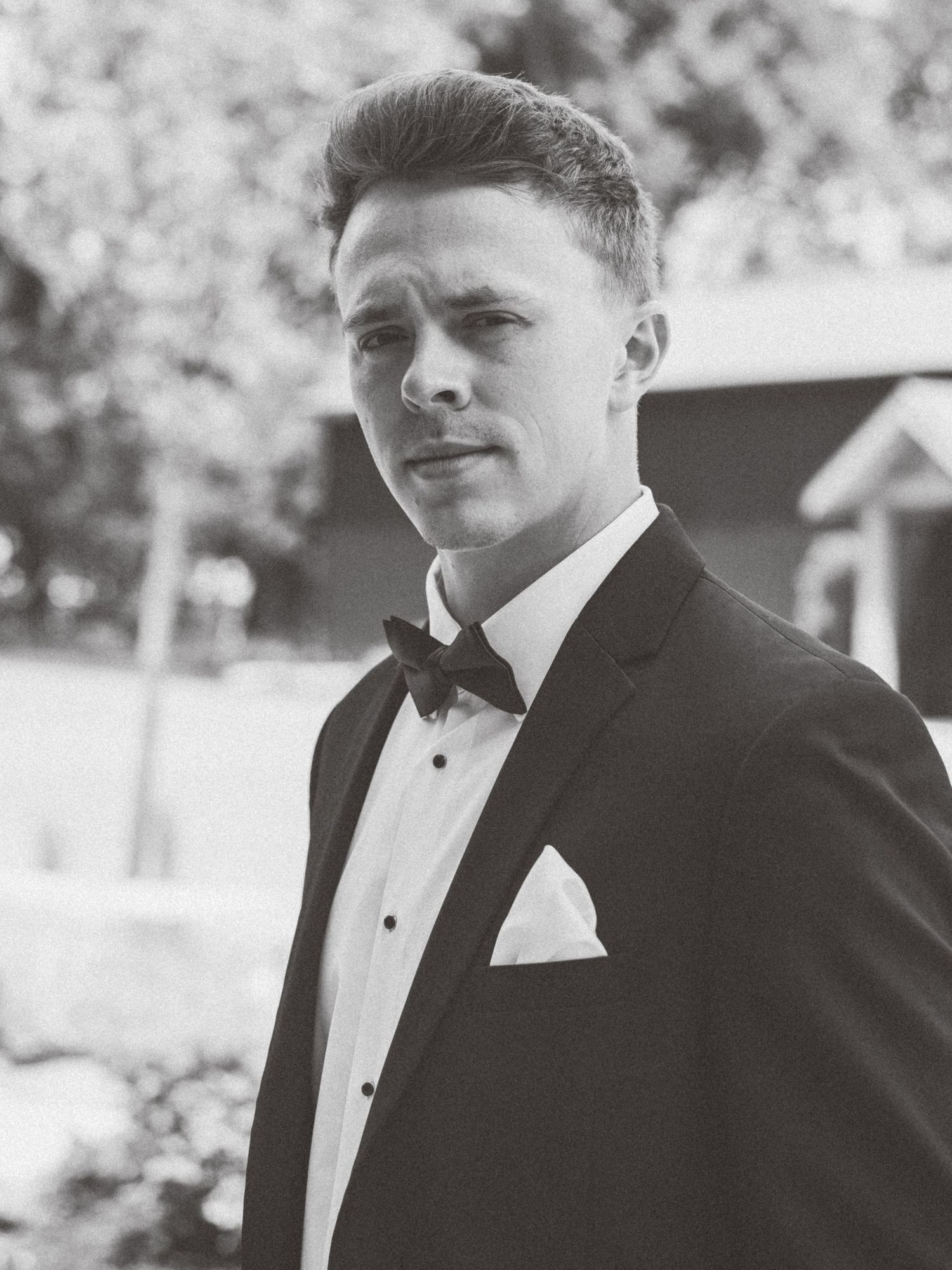 Classic black and white portrait of groom in tuxedo with bow tie.