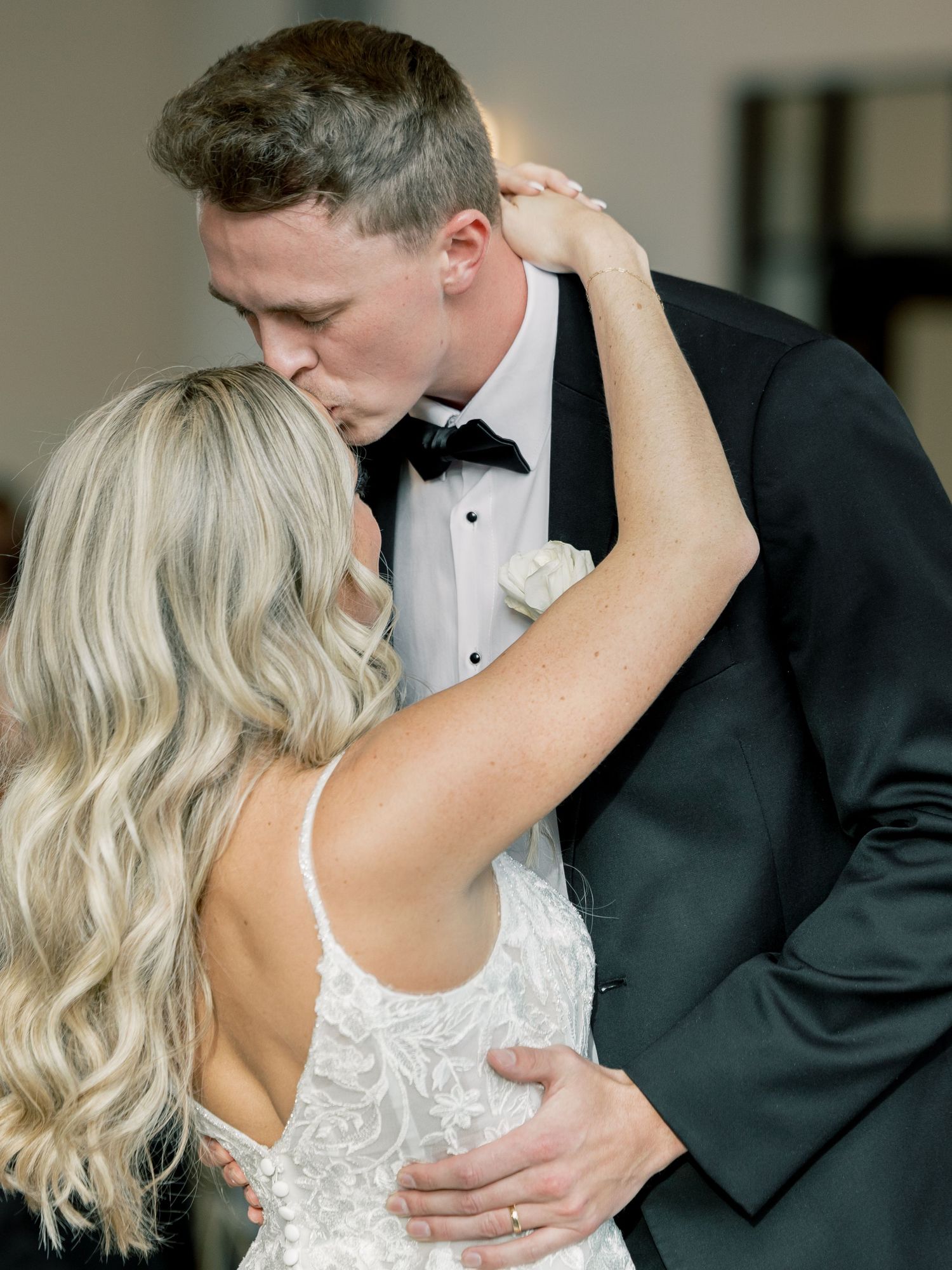 Intimate wedding dance moment captured in black and white formal attire.