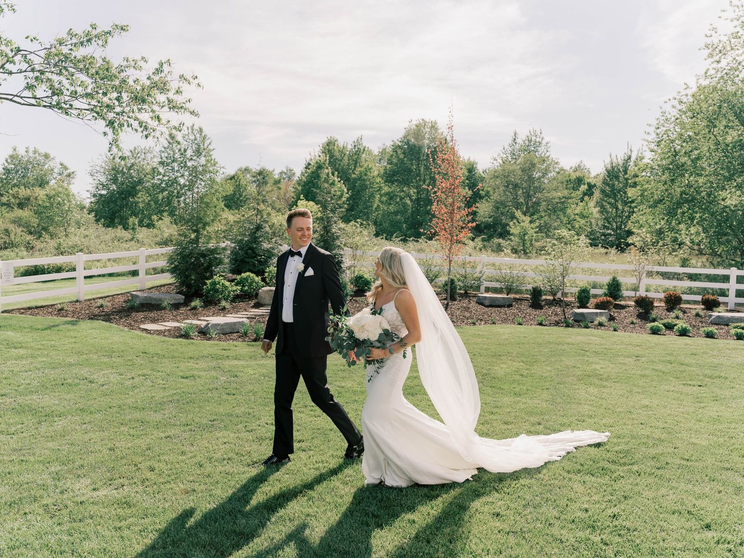 Wedding couple walking and posing in an open field on their special day.