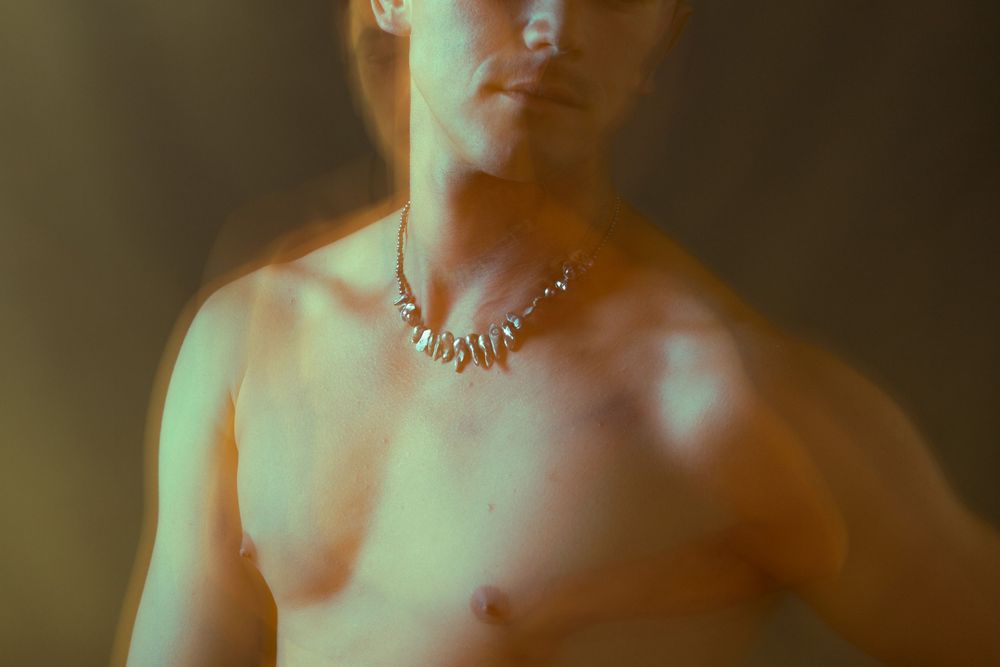 Flat lay jewelry photography of a silver chain on a black background; remote e-commerce product shooting for international accessory brands.