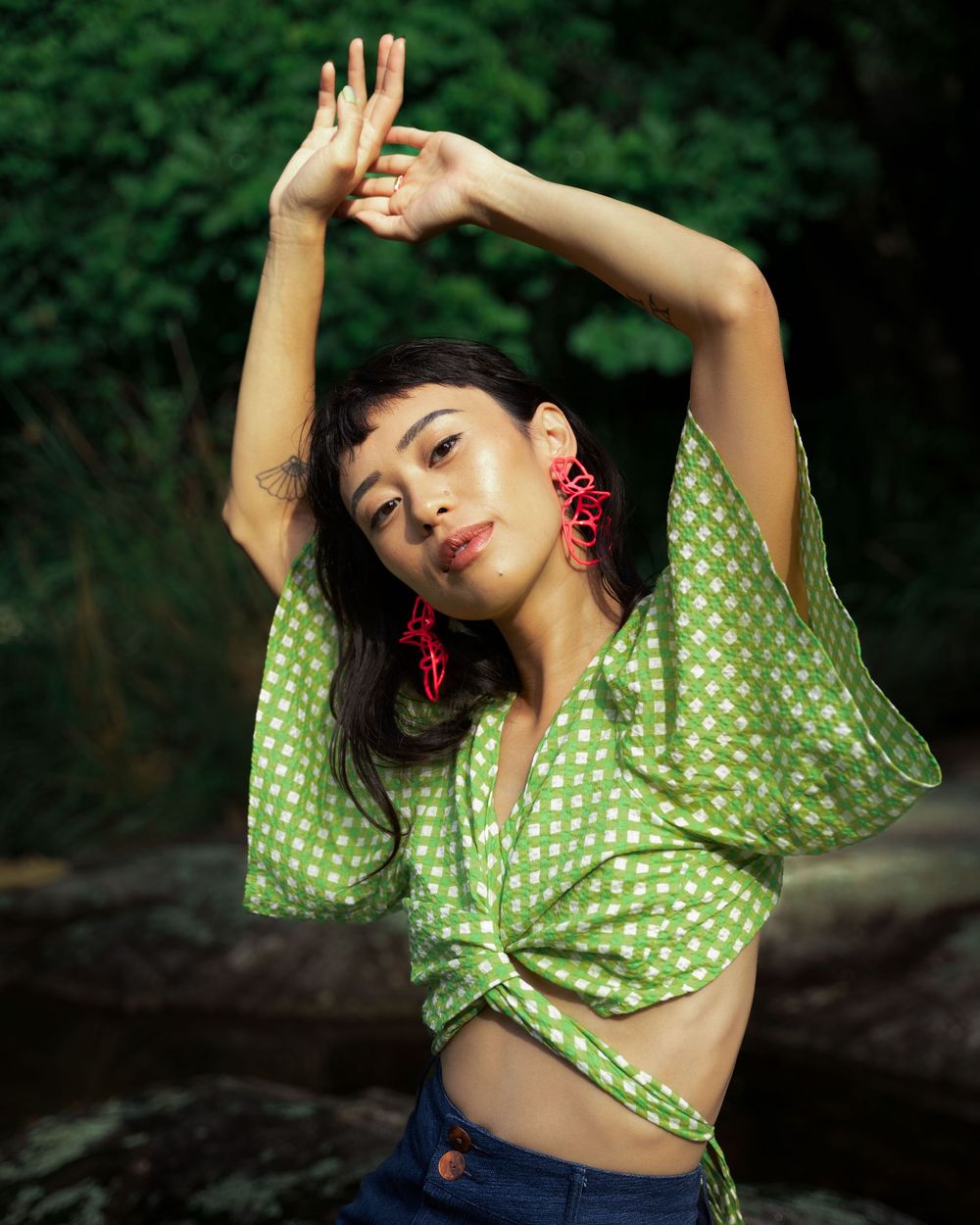Fashion shoot featuring a woman in a green top in a Tuscan field; location photography for sustainable clothing brands.