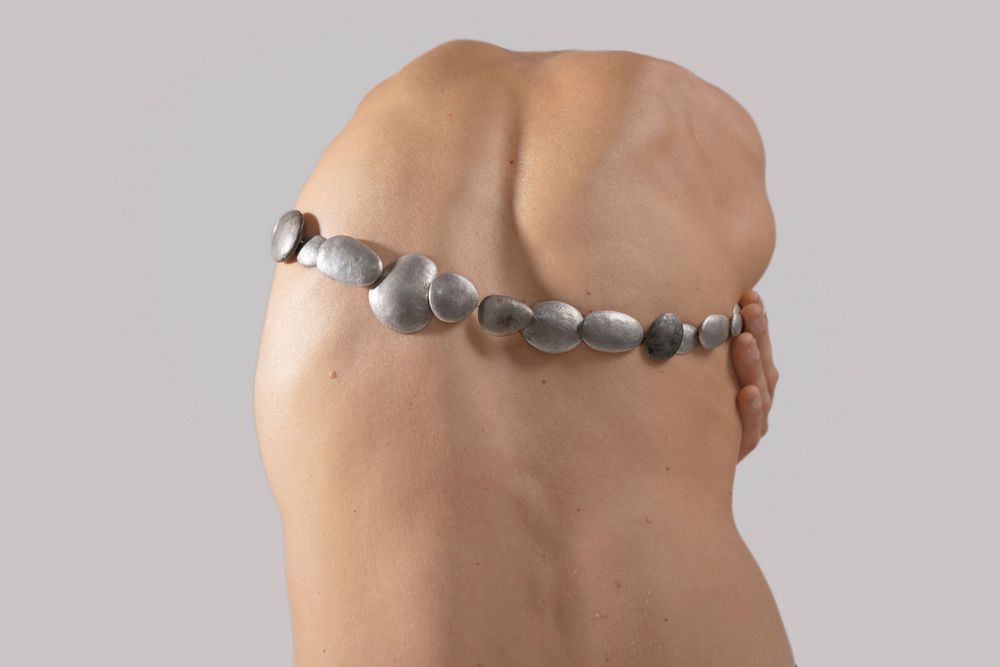 Detail shot of a silver belt on a model; commercial fashion photography for independent Italian accessory lines.