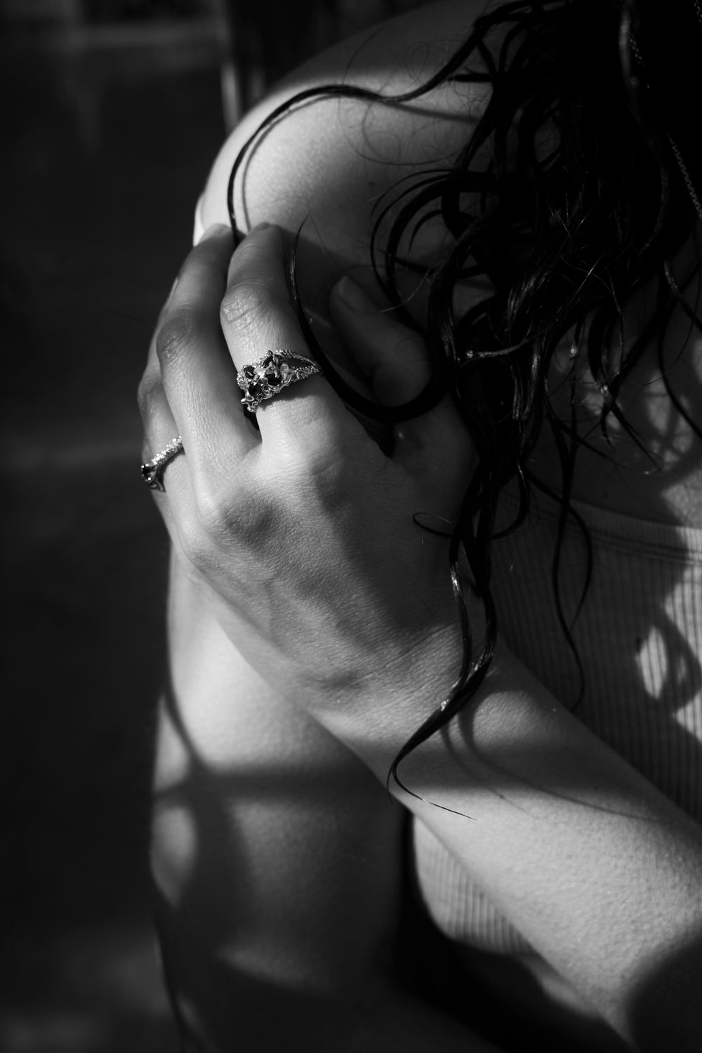 Abstract light and shadow play on a body with jewelry; high-concept editorial photography for avant-garde international brands.