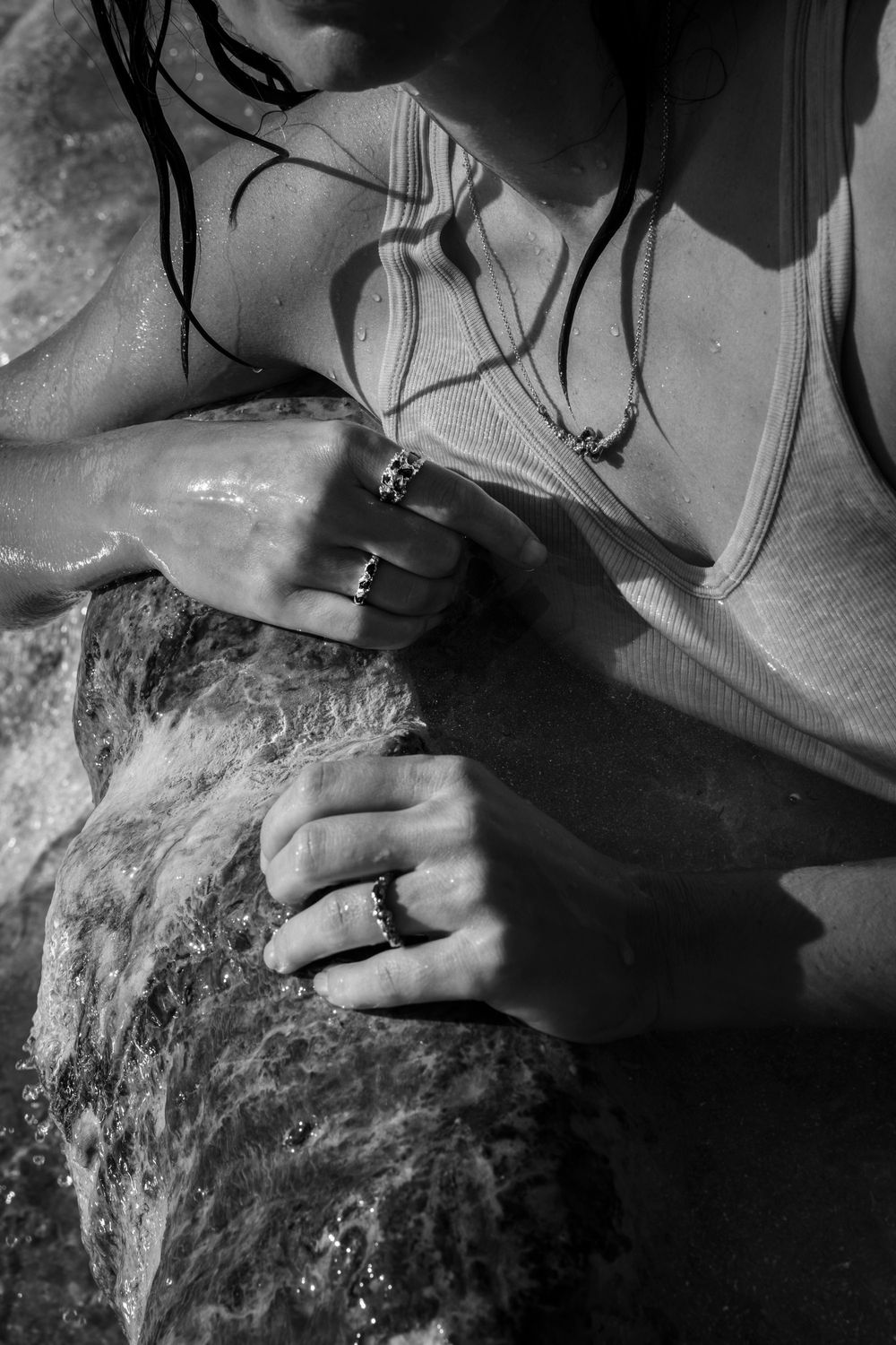 B&W close-up of hands working with raw jewelry materials; authentic artisan brand imagery for international heritage brands.