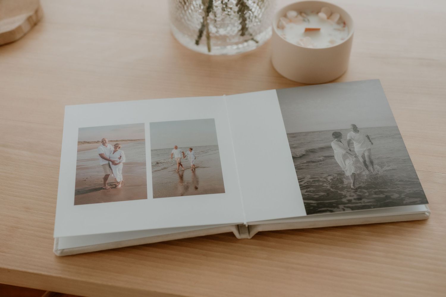 Open fotoalbum met zwart-wit familiefoto’s op een houten tafel, vastgelegd in zacht natuurlijk licht.