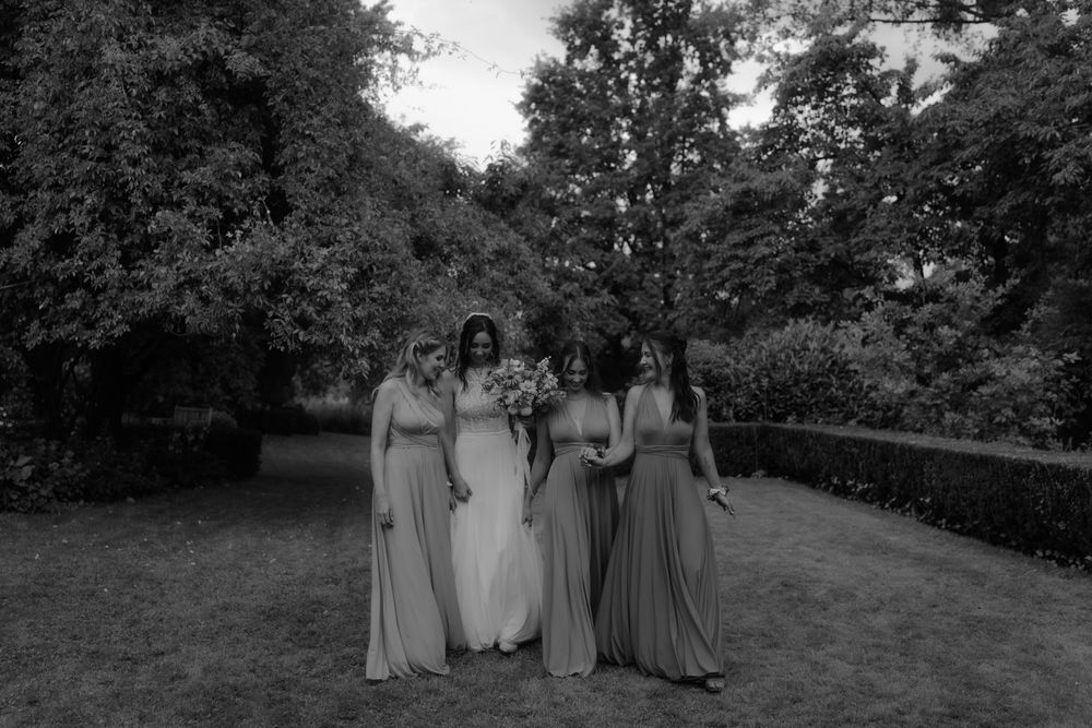 Wedding party poses together in a garden setting captured in black and white.
