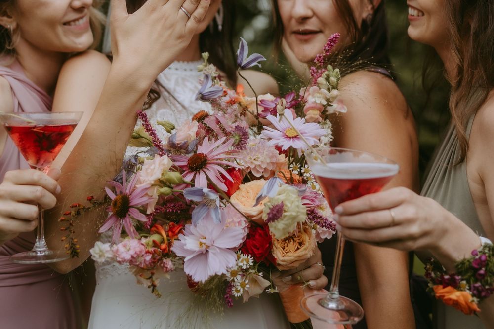 Candid moments of bridal party celebrating with drinks and flowers.