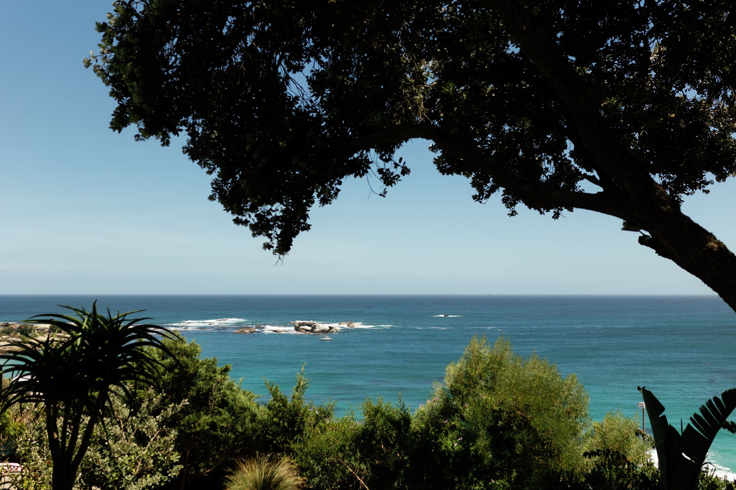 Scenic coastal views of a rocky beach with turquoise waters and lush vegetation framing multiple landscape shots.